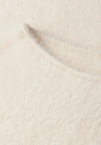 Cremfarbener, gestrickter Stoff mit einer weichen, flauschigen Textur und einem leichten Glanz; verfügt über eine glatte, abgerundete Kante und feine, zarte Fasern.