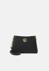 Bolso cruzado de cuero negro con un acabado mate, logo dorado de MK y una correa con detalles de cadena. Presenta una forma rectangular y cierre de cremallera.