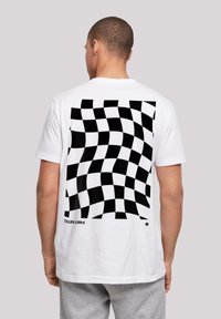 White short-sleeve t-shirt featuring a black and white checkered pattern on the back. Soft cotton material with a relaxed fit.