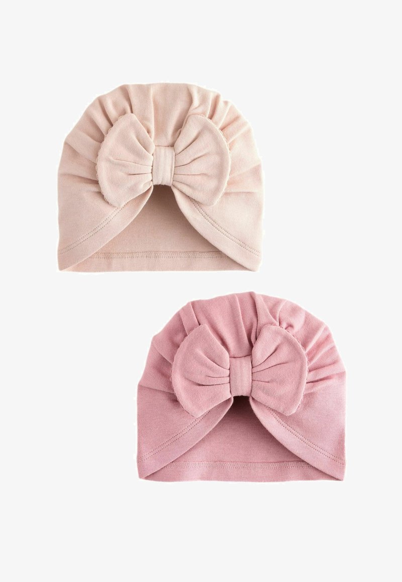Dos turbantes de tela suave para bebé en rosa claro y rosa envejecido, cada uno con un lazo grande en el centro y detalles fruncidos.