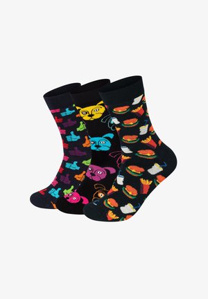 Trzy pary skarpetek do połowy łydki: jedna w kolorowe kciuki, jedna z twarzami zwierząt, a jedna z motywami jedzenia, takimi jak burgery i frytki.