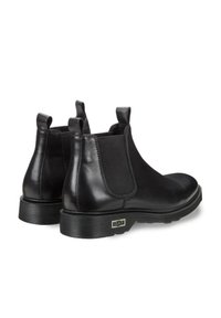 Czarne skórzane botki typu Chelsea z elastycznymi panelami bocznymi. Okrągły czubek, teksturowana gumowa podeszwa oraz uchwyty z tyłu. Subtelne logo na pięcie.