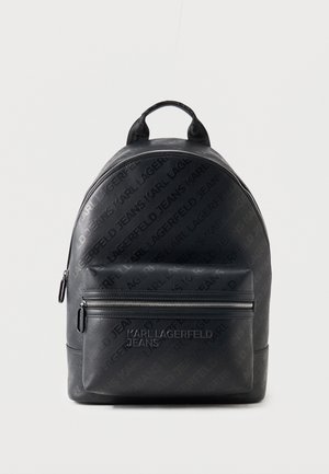 Sac à dos noir Karl Lagerfeld Jeans avec motif de logo en relief et poche avant zippée sur un fond clair uni.
