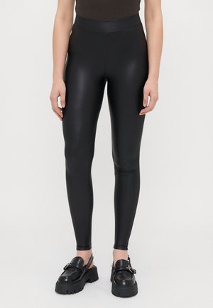 Černé legíny vyrobené z hladkého, lesklého materiálu, s vysokým pasem a slim fit, které se u kotníků zužují.