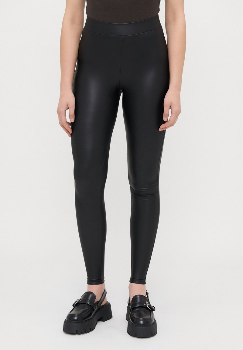 Schwarze Leggings aus einem glatten, glänzenden Material, mit einem hohen Bund und einer schlanken Passform, die sich an den Knöcheln verjüngt.