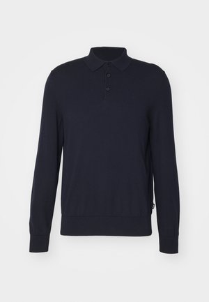 Polo bleu marine à manches longues avec trois boutons, poignets côtelés et ceinture sur fond blanc.