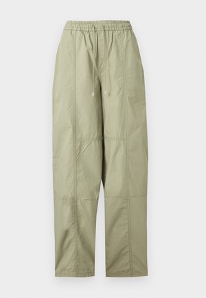 Pantalon ample vert clair avec taille élastique et cordon de serrage, présentant des coutures apparentes et des jambes droites.