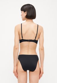 Black bikini set featuring a simple design with adjustable straps, seamless edges, and minimal hardware for a sleek look.