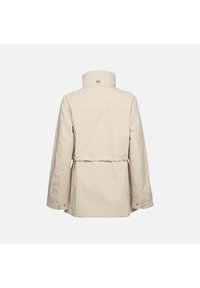 Giacca esterna beige con colletto alto, maniche lunghe, vita elasticizzata e bottoni a pressione. Tessuto dalla texture liscia, design minimalista.