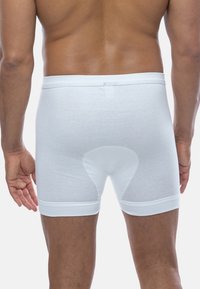 Boxer in cotone bianco con un design aderente, caratterizzati da una texture liscia, un elastico in vita e un dettaglio di cucitura a contrasto.