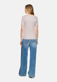 Helles graues Kurzarmoberteil mit rundem Halsauschnitt, kombiniert mit locker sitzenden, hellblauen Jeans aus Denim mit einem ausgewaschenen Aussehen.