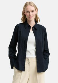 Navy button-up shirt with a collar, long sleeves, and a relaxed fit. Made from smooth fabric with a subtle sheen and no visible patterns.