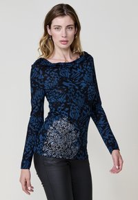 Camiseta de manga larga en azul marino y negro, con un patrón floral texturizado y acentos plateados en el lateral. Tejido suave con un cuello relajado.