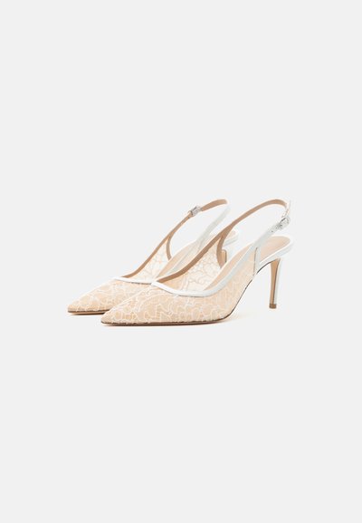 Escarpins slingback en dentelle beige à bout pointu avec fines lanières blanches et talons aiguilles de hauteur moyenne, inclinés sur fond blanc.