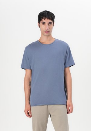 Short-sleeve, crew-neck t-shirt in light blue, made of soft fabric. Features a relaxed fit with a regular hem and subtle side slits.