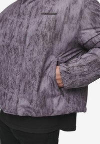 Gewatteerd jack van gestructureerde grijze stof met een gemarmerd patroon. Voorzien van een zak met rits en een logo-accent op de borst.