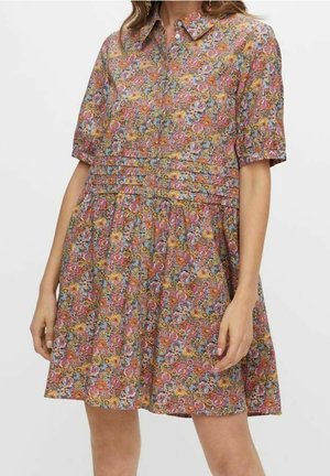 Multikleuren bloemenjurk met korte mouwen en een knoopsluiting aan de voorkant. Beschikt over plooien bij de taille en een losse, uitlopende rok. Zachte stoftextuur.