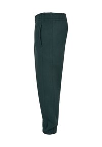 Dunkelgrüne Sweatpants mit einem elastischen Bund, seitlichen Taschen, engem Schnitt und weichem Stoff, geeignet für Freizeitbekleidung.