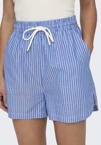 Modré pruhované šortky s bílým stahovacím páskem. Vyrobené z lehkého materiálu, s bočními kapsami a olemovaným okrajem.