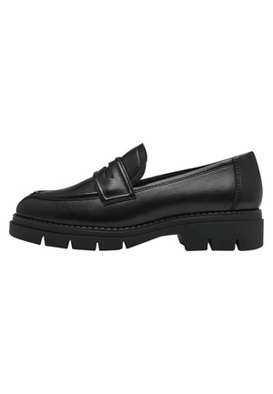 Mocassin en cuir noir avec une semelle épaisse et texturée. Il présente un design brodé subtil et une sangle décorative sur le devant.