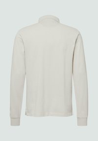 Lange mouw polo shirt in lichtbeige, gemaakt van zachte stof met een klassieke kraag en geribde mouwen, met een eenvoudige, minimalistische uitstraling.