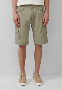 Beige cargoshorts met vier zakken, stevige stof en een vlakke voorkant. Gekocht met lichtbruine sneakers, met veters en een gestructureerd oppervlak.