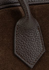 Tamnosmeđa teksturirana kožna i antilop torba s detaljima od šivene kože i petljom za remen.