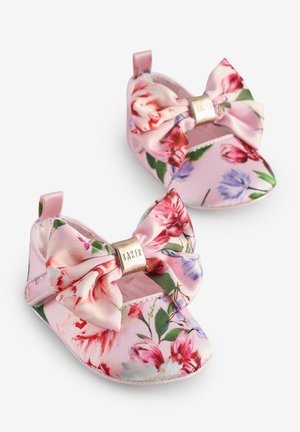 Blumen Babyschuhe aus weichem rosa Stoff, mit großem Schleifenelement und goldenen Akzenten. Das Muster umfasst Rosen und andere Blumen auf einem hellen Hintergrund.