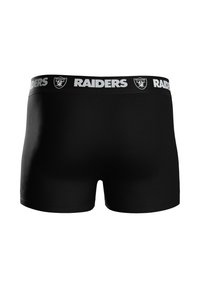 Czarne bokserki z szerokim pasem w talii, na którym znajduje się napis "RAIDERS" w białym kolorze oraz logo. Gładka faktura, dopasowany krój. Brak dodatkowych wzorów.