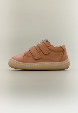 Tan leather sneaker with two Velcro straps, rounded toe, and a light rubber sole. Features minimal stitching and a small accent at the heel.