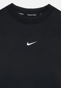 Nike Pro schwarzes Sport-Shirt mit Rundhalsausschnitt und kleinem weißen Swoosh-Logo auf der Vorderseite. Glatte, dehnbare Stofftextur.