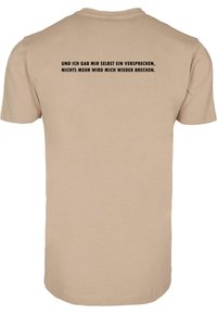 Beige puuvillane t-särk lühikeste varrukatega, mille seljal on must kiri saksa keeles: isiklik lubadus mitte uuesti petta.
