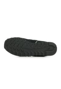 Sole di scarpa da ginnastica nera con motivi di grip testurizzati. Presenta gomma stampata per trazione e durata, con tallone rinforzato per supporto.