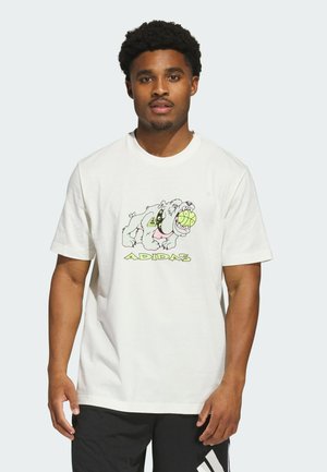 Man wearing white Adidas t-shirt with cartoon bulldog biting a green tennis ball and black Adidas shorts with white stripes.