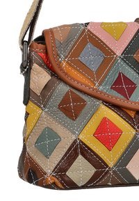 Bolso de cuero multicolor con un patrón acolchado en forma de diamante y varios paneles texturizados. La solapa está bordeada con un ribete marrón.