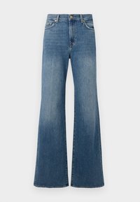 Jean flare en denim bleu, avec une taille haute, des jambes larges et des détails usés sur la surface.