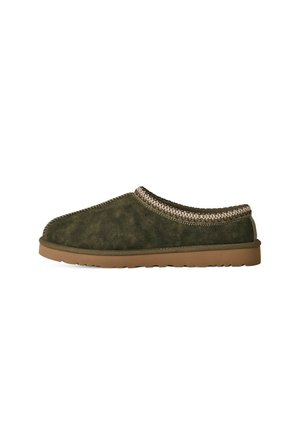 Zapatilla de estar por casa de ante verde oscuro con suela de goma marrón y ribete tejido alrededor de la abertura.