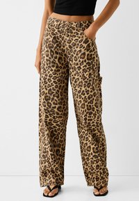 Leopardprint wijdlopende broek in een bruine en tan kleurenschema, van katoen, met zijzakken en een hoge taille.