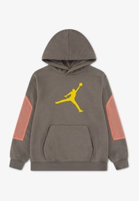 Γκρι φλις φούτερ με κίτρινο λογότυπο Jordan. Διαθέτει ροζ τονισμένες πανέλες στα μανίκια, μια μπροστινή τσέπη καγκουρό και κουκούλα με κορδόνι.
