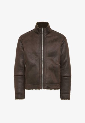 Pruun nahast jakk kõrge kaelusega, ees lukuga ja küljetaskutega. Omab tekstureeritud pindmiste ja siledat vooderdust kaeluses ja alumises servas.