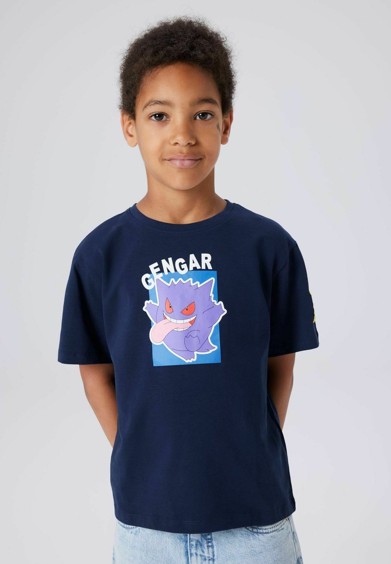 Marineblå bomulls-T-skjorte med et bilde av Gengar, en lilla Pokémon med røde øyne og bredt smil; løs passform, korte ermer, avslappet design.