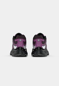 Purple and black running shoes with a textured upper, reflective accents, and a patterned sole, featuring a padded collar and tongue.