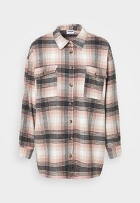 Camicia a quadri in morbido flanella, con colori rosa, bianco e nero, apertura con bottoni, due tasche sul petto e maniche lunghe.
