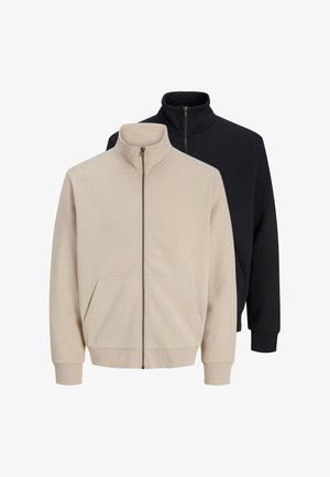 Zwei schlichte Reißverschlussjacken, eine beige vorne und eine schwarze hinten, beide mit hohen Krägen und Vorder Taschen.