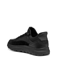 Svart sneakers i en kombination av slät läder och texturerad mocka. Utvecklad med en dämpad sula och kurviga, vågiga mönster på yttersulan.