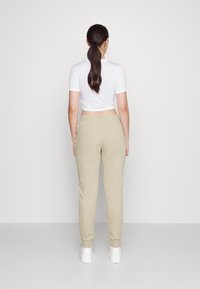 Nike Sportswear Calças de fato de treino - rattan/white