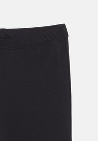 Μαύρο κολάν με ελαστική μέση, κατασκευασμένο από απαλό, ελαστικό ύφασμα; λεία υφή με ελάχιστες ραφές.