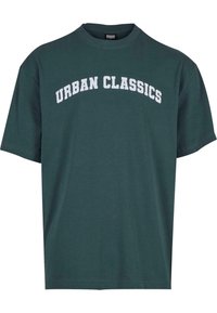 Zöld pamut póló, rövid ujjú, kerek nyakkivágással, rajta fehér ívelt betűkkel a "URBAN CLASSICS" felirattal az elején.