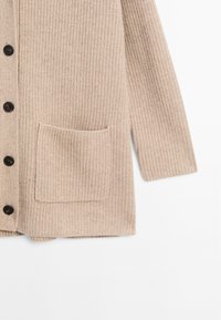 Beige pletený kardigan s ribbovanou strukturou, pěti černými knoflíky a jednou přední kapsou. Rukávy jsou dlouhé a rovné.