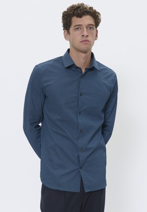 Camisa de manga larga azul marino hecha de tejido entrelazado, con un pequeño patrón geométrico blanco, cuello abotonado y botones marrones.